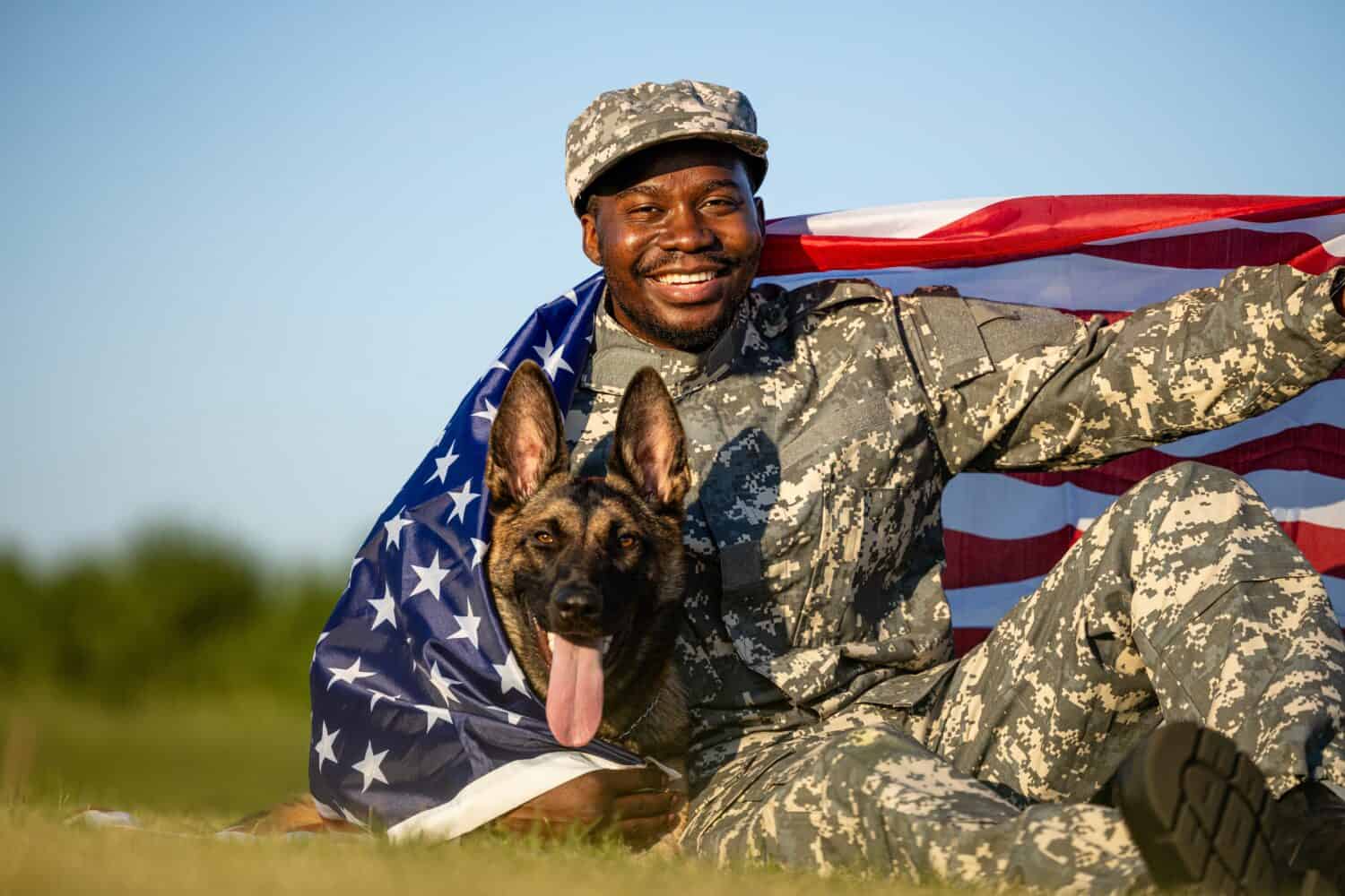 Pride of the USA. Soldier and military dog covered with American national flag celebrating Independence day.