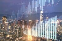 An overhead view of a sparkling city skyline at dusk or night, with numerous illuminated skyscrapers and buildings. Overlaid on the scene is a translucent blue bar chart and a red line graph, displaying financial data points including percentages like 2.95%, 6.28%, 9.34%, and numerical axes ranging from 10 to 150 horizontally and 10 to 60 vertically.