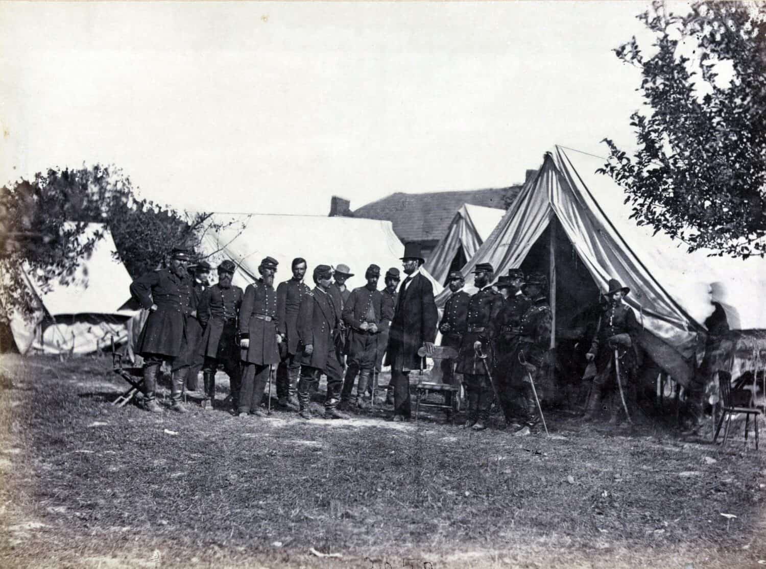 President Lincoln (1809-1865) on battle-field of Antietam with several officers outside tent.