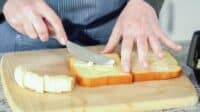 In a modern white kitchen, buttered banana and brioche bread are being prepared for making a delicious grilled peanut butter banana sandwich.