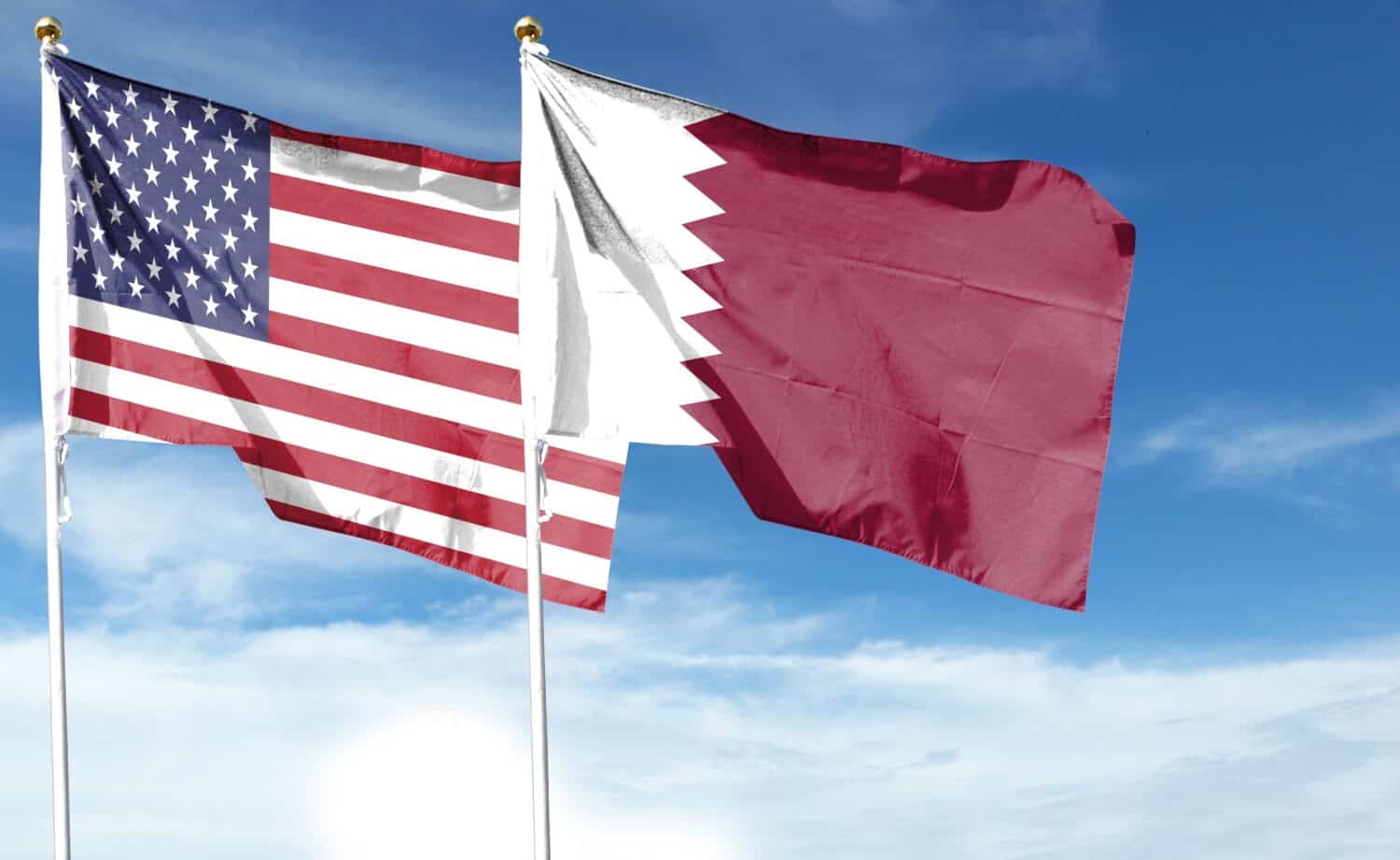 American flag and Qatar flag on cloudy sky. fly in the sky