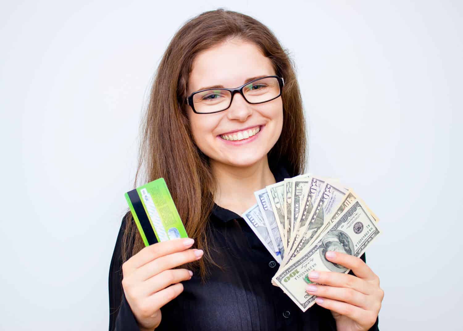 business, finance, saving, banking and people concept - close up of woman hands holding us dollar money and credit card