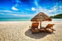 Vacation holidays background wallpaper - two beach lounge chairs under tent on beach. Sihanoukville, Cambodia