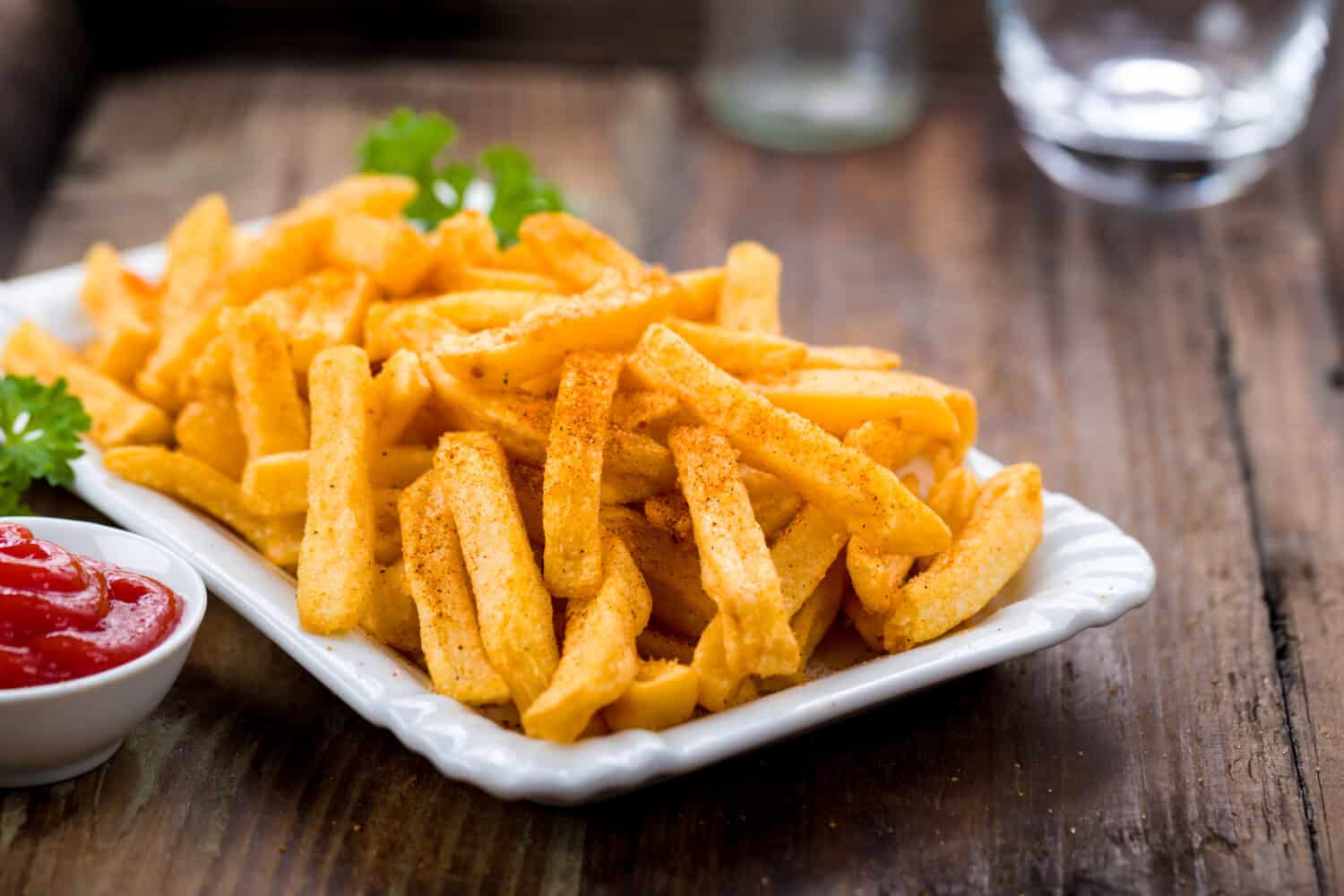 French fries in a bowl on a wooden background