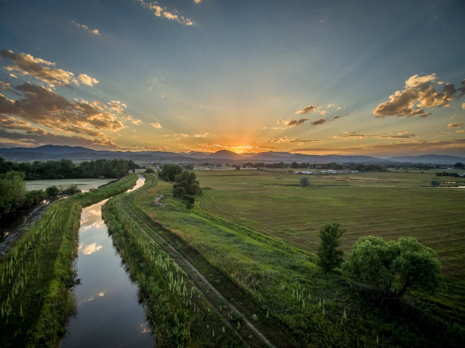 sunset over Rocky Mountains and foothills with an irrigation ditch - aerial view, northern Colorado near Loveland