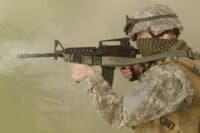 US army soldier firing M4 carbine in the desert during the military operation in desert