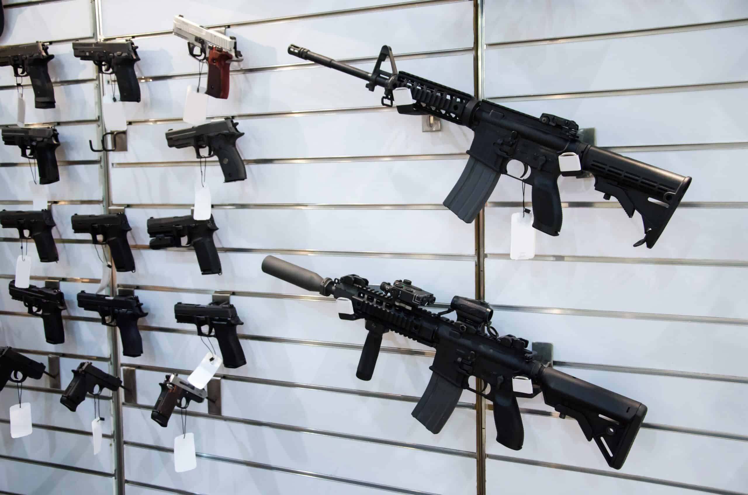 Arkansas gun show gun shop | Gun wall rack with rifles and pistol.