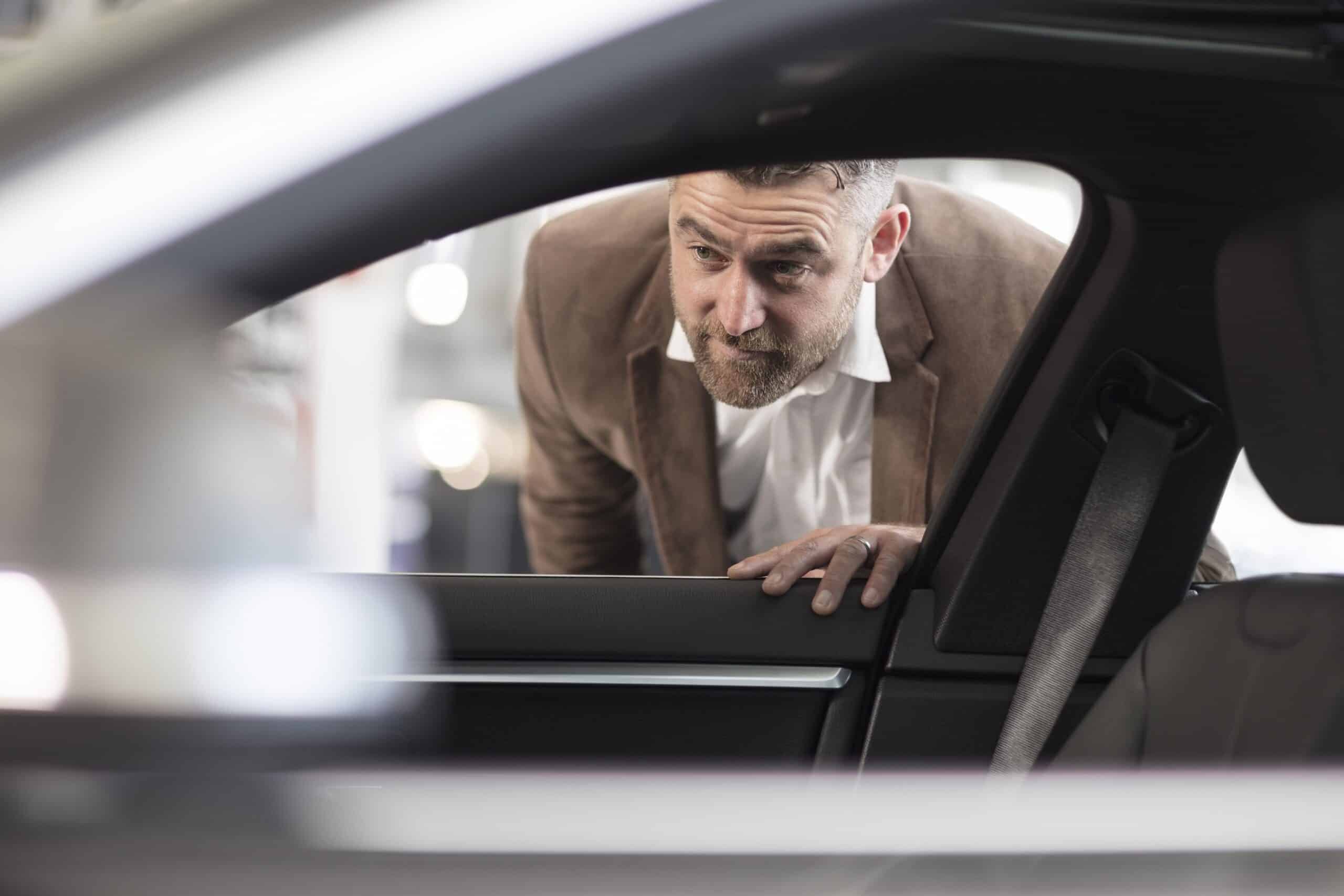 Independent dealership | Man looking into car in car dealership