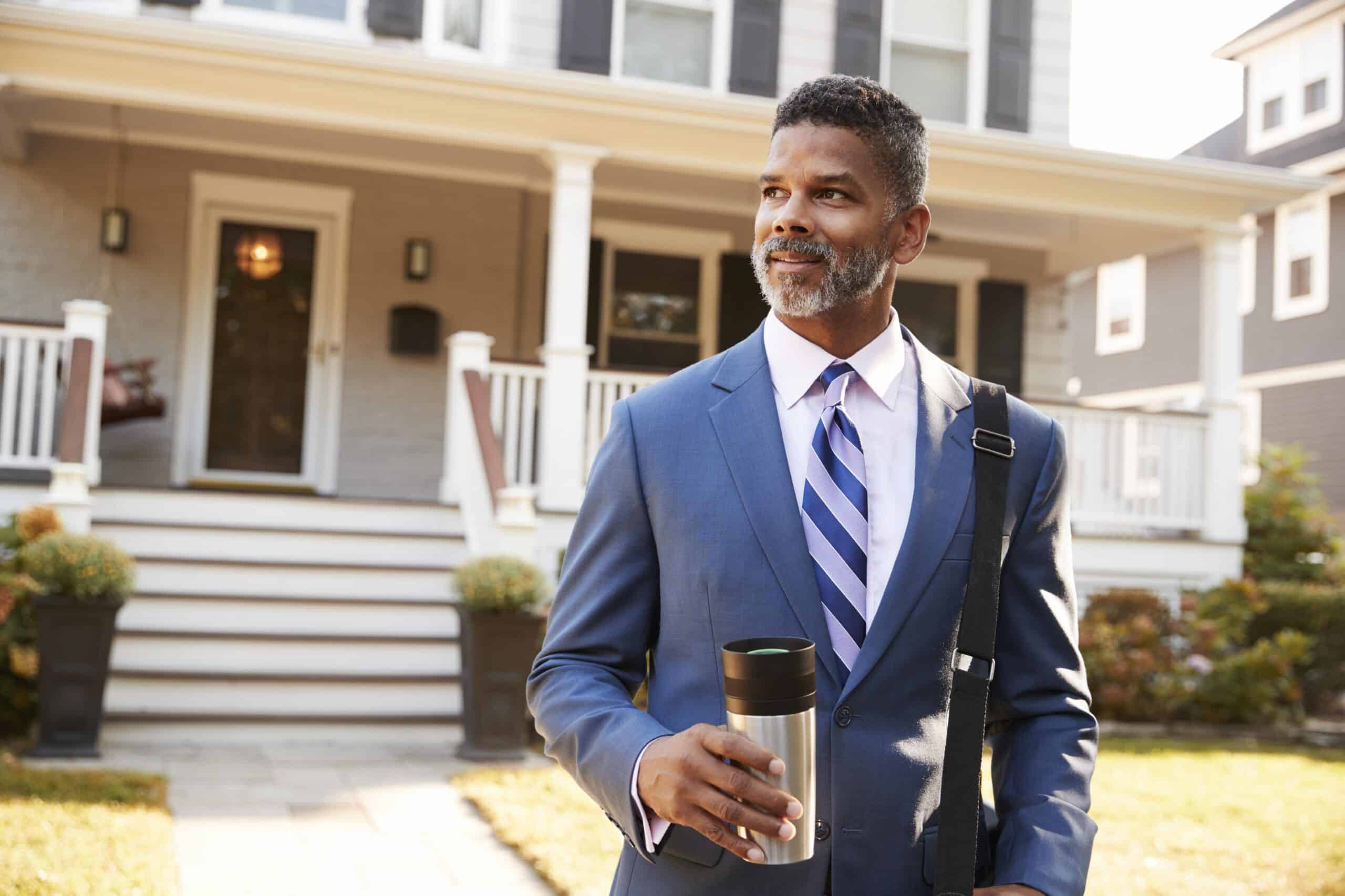 middle aged Americans | Businessman With Cup Of Coffee Leaving Suburban House For Work