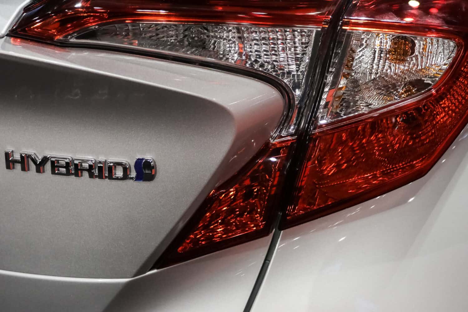 Hybrid logo detail of a car exhibited during a motor show.