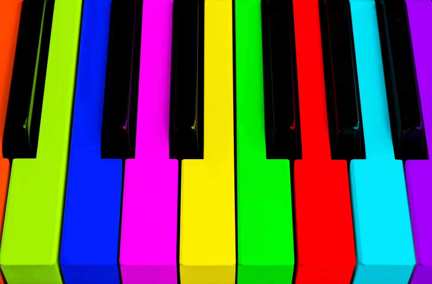 Top view of multicolored piano keys. Close-up of piano keys. Close frontal view. Piano keyboard with selective focus. Top view. Colorful Piano keyboard perspective with red button. Soft lighting
