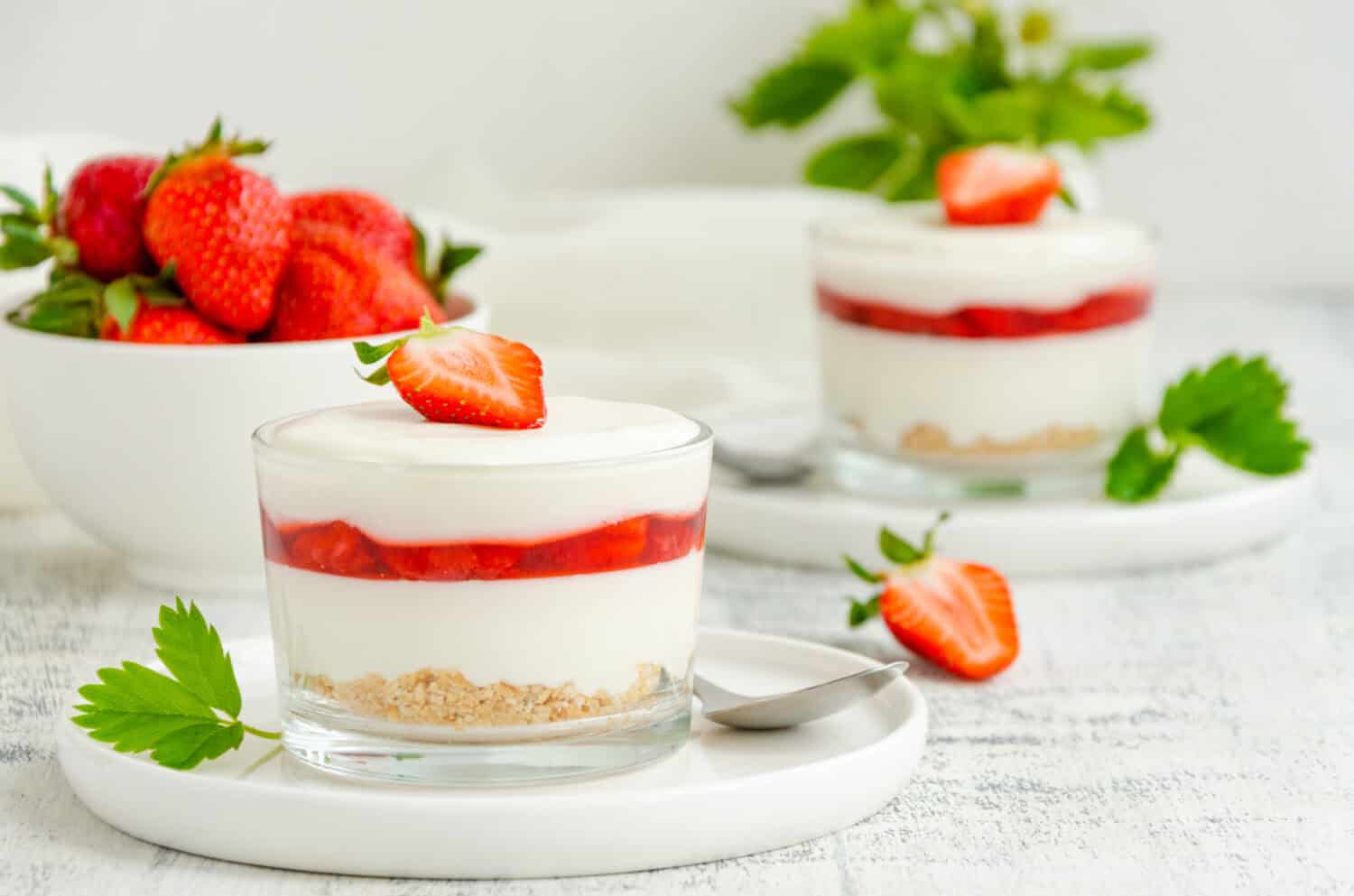No baked strawberry cheesecake in a glass on a wooden background. Summer cold dessert. Horizontal, copy space