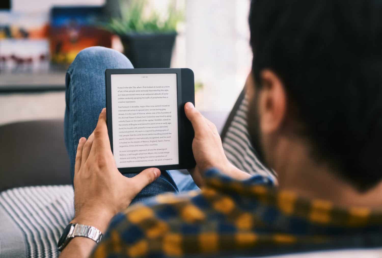 Young Man Holding Ereader And Reading Ebook