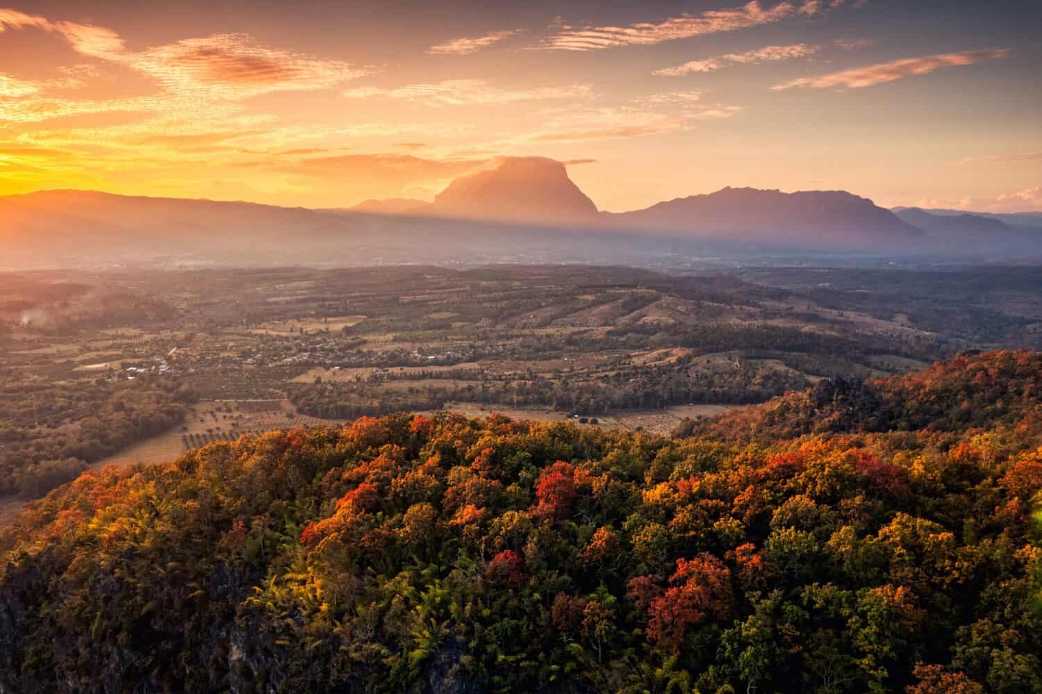 Aerial view of sunset over Doi Luang Chiang Dao mountain range with colorful autumn forest on hill in countryside at Chiang Dao, Chiang Mai, Thailand