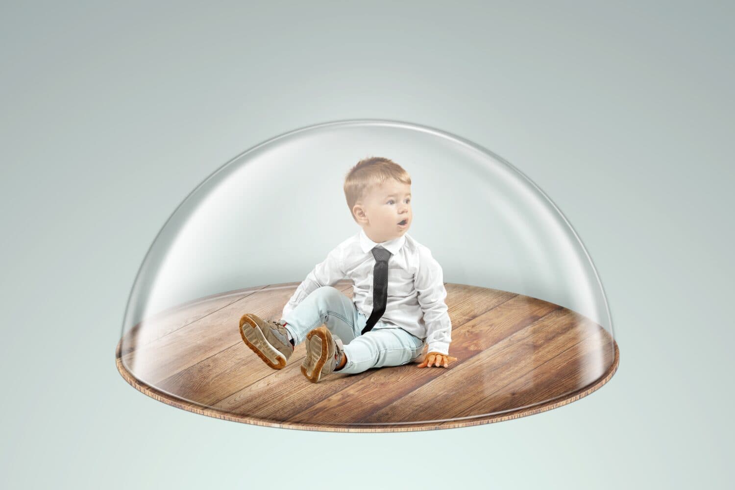 Child safety, overprotection, a little boy sits under a glass dome, cap. Vaccinations, protection against viruses and diseases, maternal love, immunity.