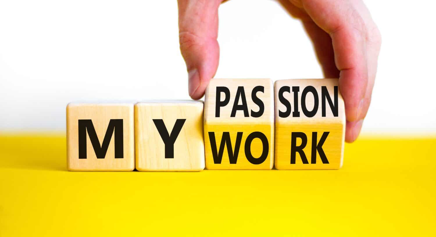 My work or passion symbol. Businessman turns wooden cubes and changes words 'My work' to 'My passion'. Beautiful white table, white background, copy space. Business and my work or passion concept.