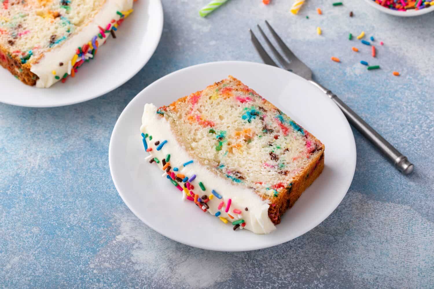 Birthday cake or funfetti pound cake with sprinkles and frosting sliced ready to eat