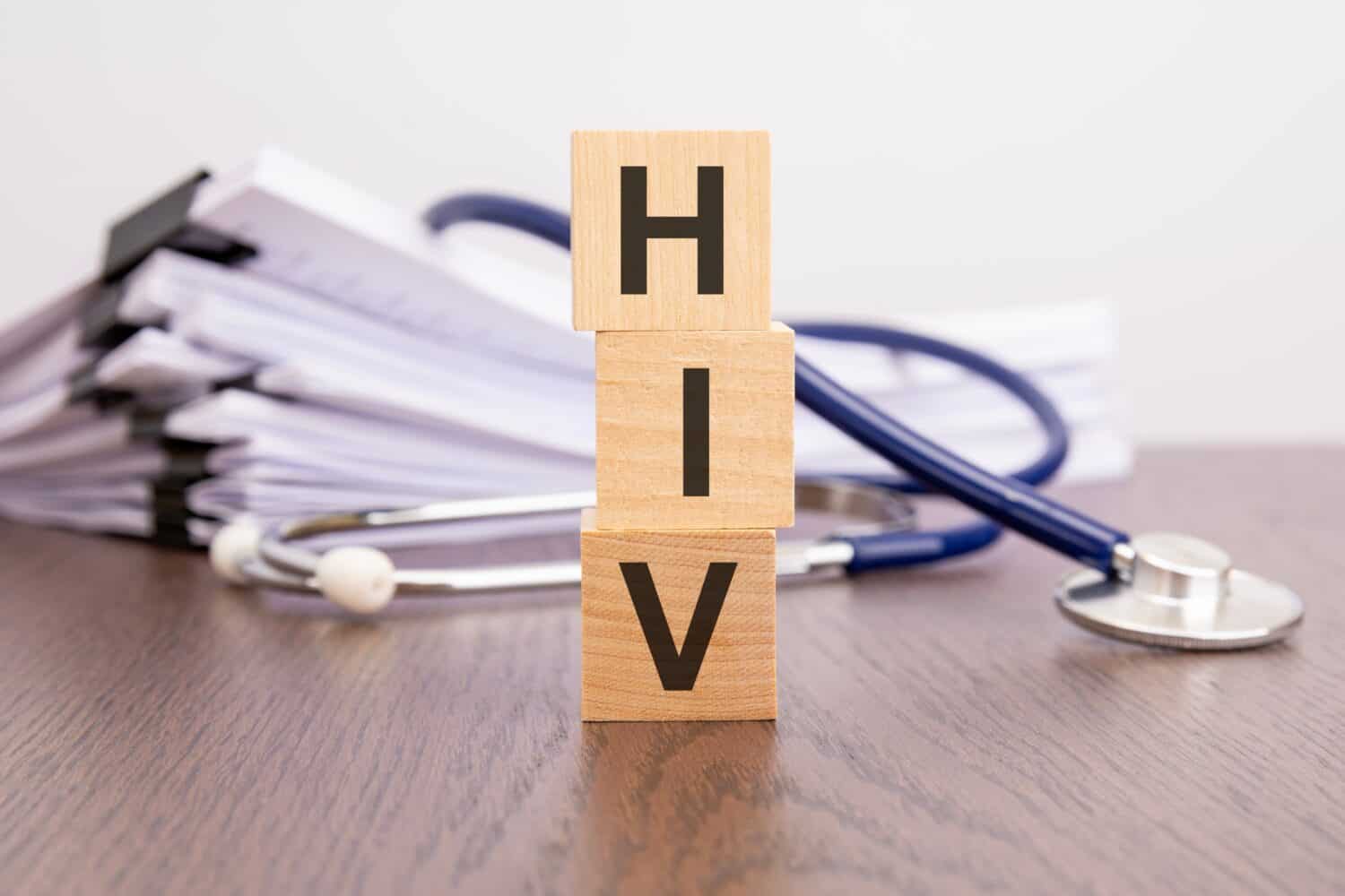 text HIV written on wooden blocks near a stethoscope on a paper background, medical concept