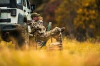Hunter Seating Next to His All Wheel Drive Vehicle and Drinking Hot Coffee From His Thermos