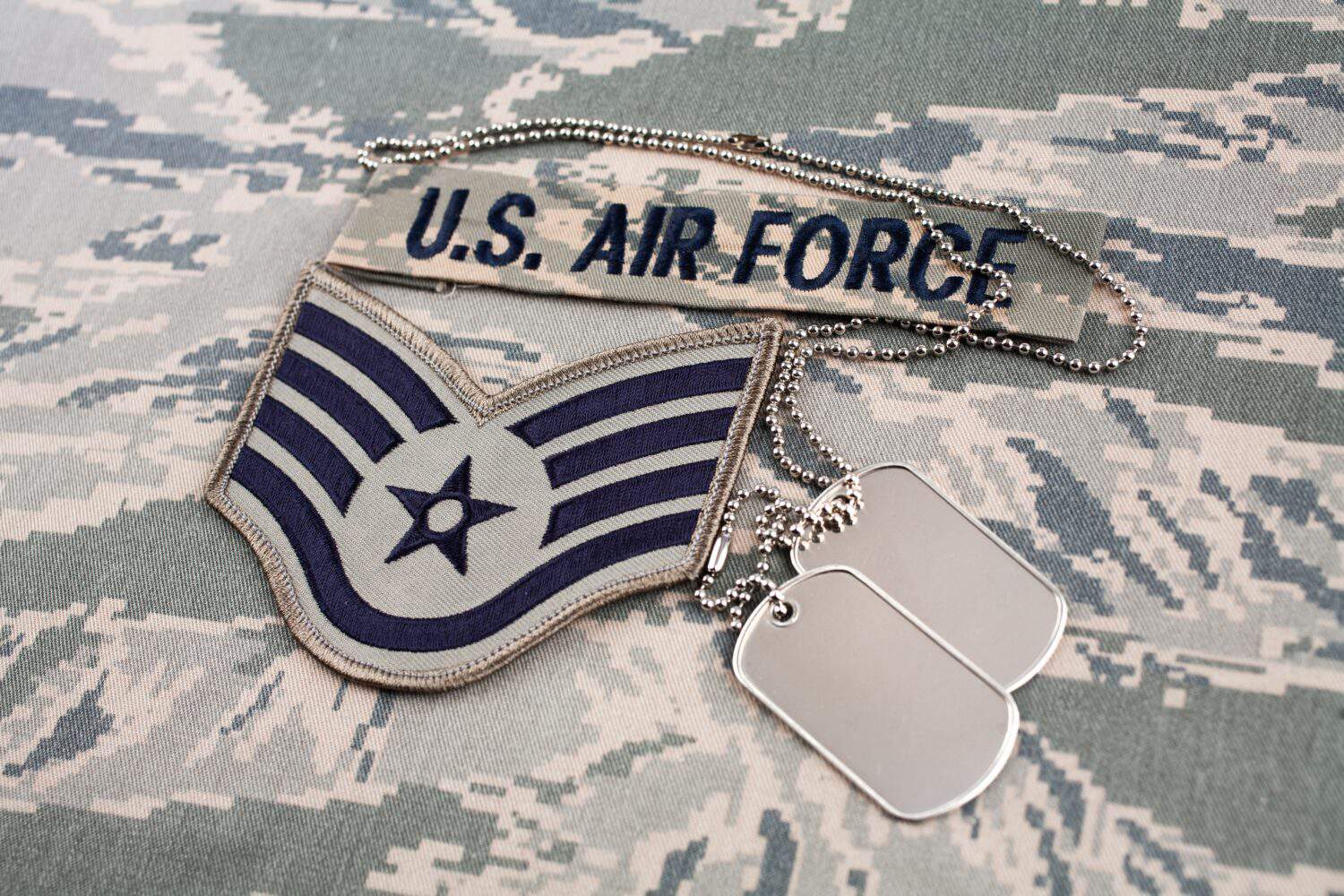 US AIR FORCE branch tape and Staff Sergeant rank patch and dog tags on digital tiger stripe pattern Airman Battle Uniform (ABU) background