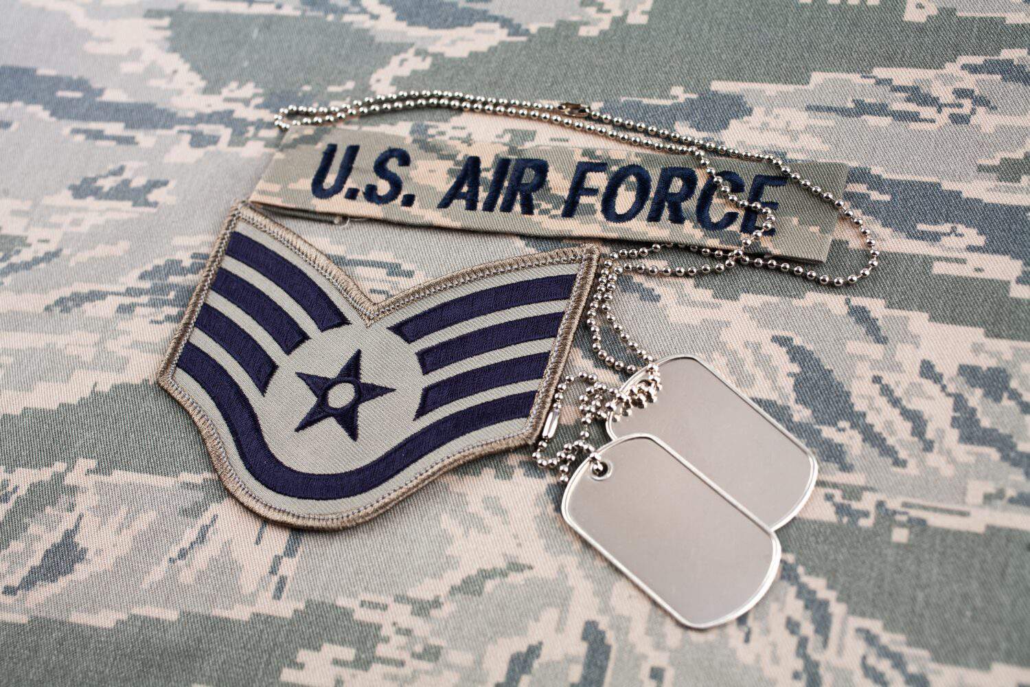 US AIR FORCE branch tape and staff sergeant rank patch and dog tags on digital tiger stripe pattern background.