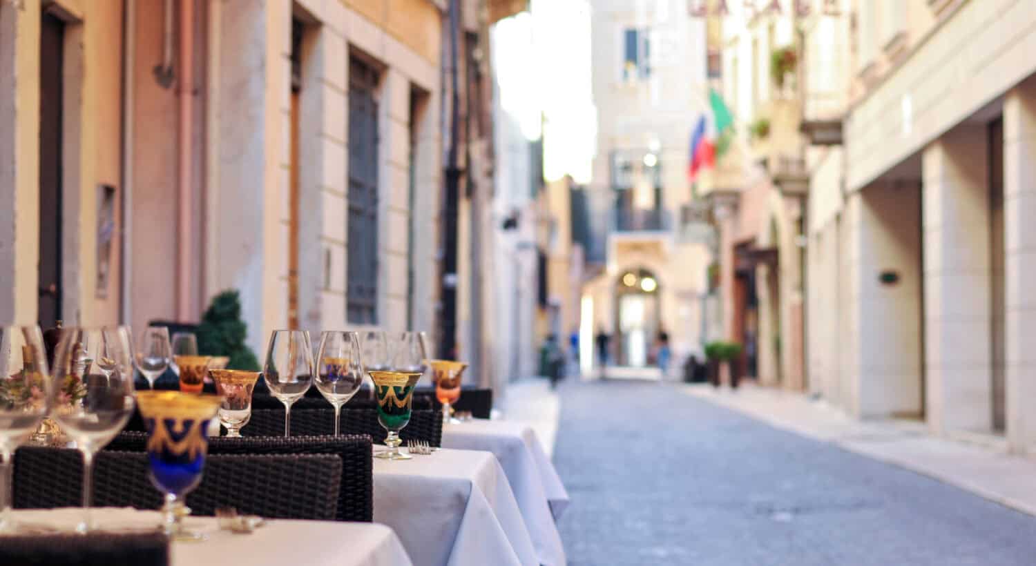 Fancy italian streets full of restaurants with wine glasses in Bologna, Italy