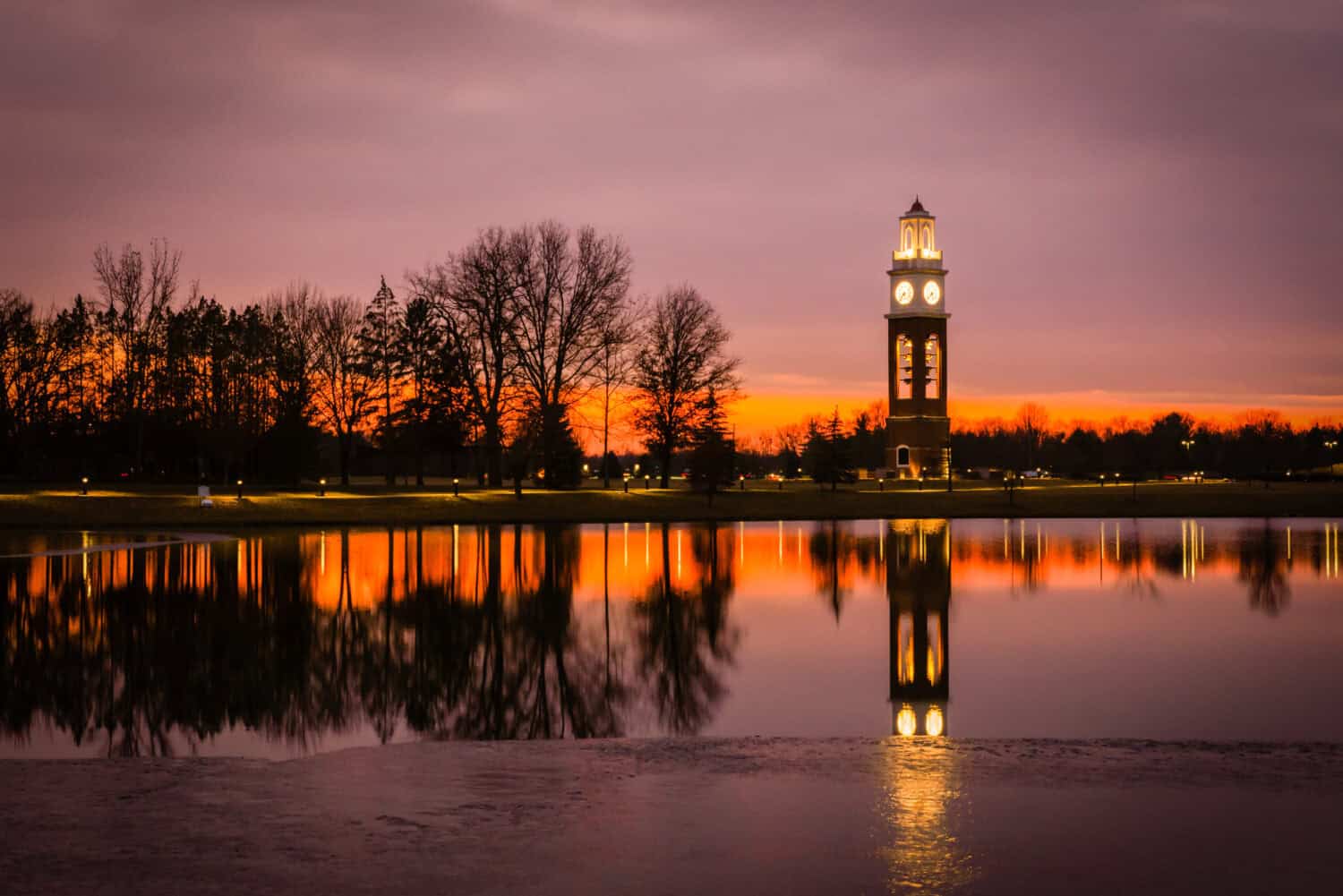 Bell tower and lake at Coxhall Garden in Carmel Indiana at sunset in the winter of 2019