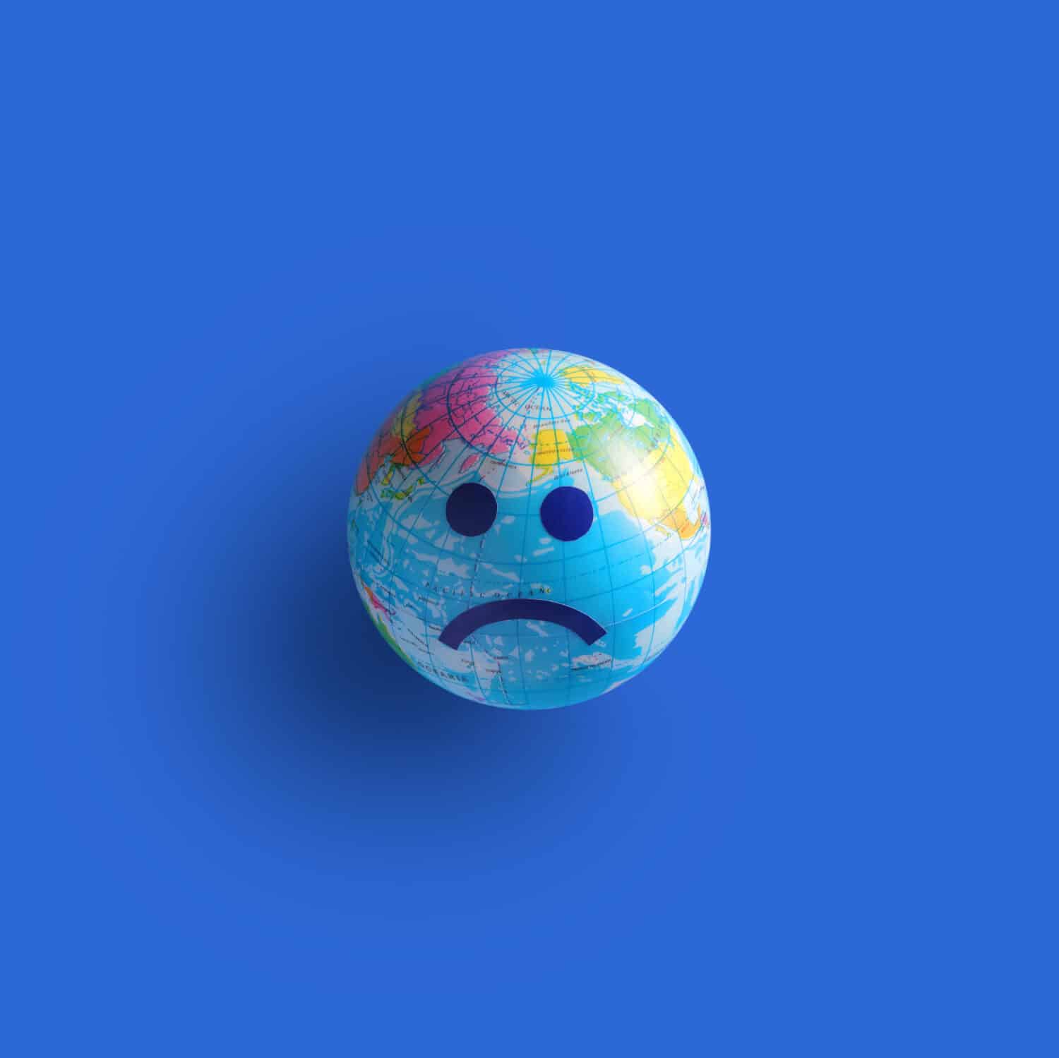 unhappy world globe on blue background with copy space, minimal style