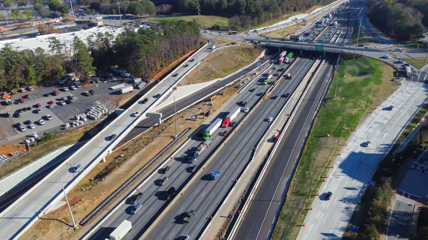 Busy traffic along Highway I-285 (the Perimeter) with under construction service road, bypass near Ashford Dunwoody in midtown Atlanta, Georgia, USA. Aerial view modern multiple lanes infrastructure