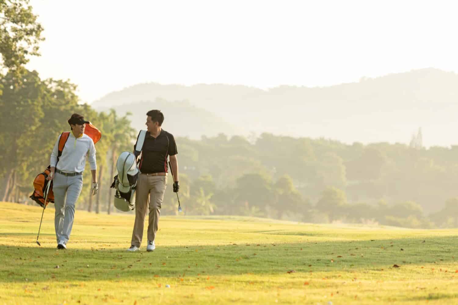 Group golf professional Golfer asian man walking in fairway with bag golf at golf club. Hobby in holiday and vacation with friends. Lifestyle and Sport Concept