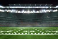 green field in american football stadium. ready for game in the midfield