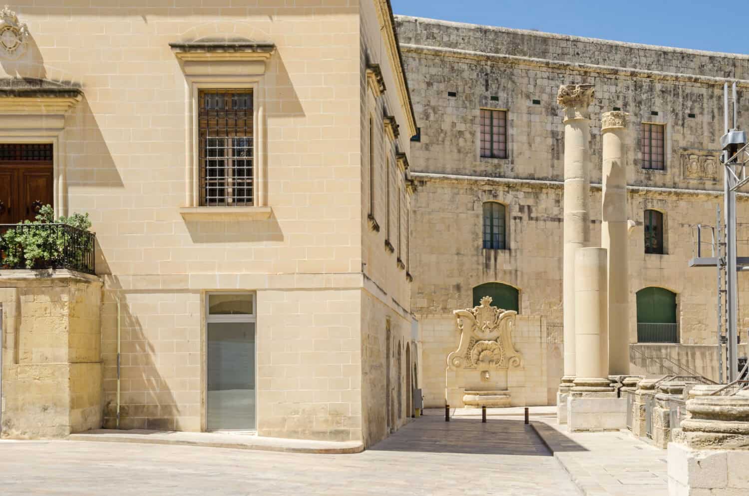 Ordnance street with the ruins of the demolished Opera House at Pjazza Teatru Rjal (Royal Theatre Square) with the baroque water well at the wall of the House of the Annona in Valletta, Malta