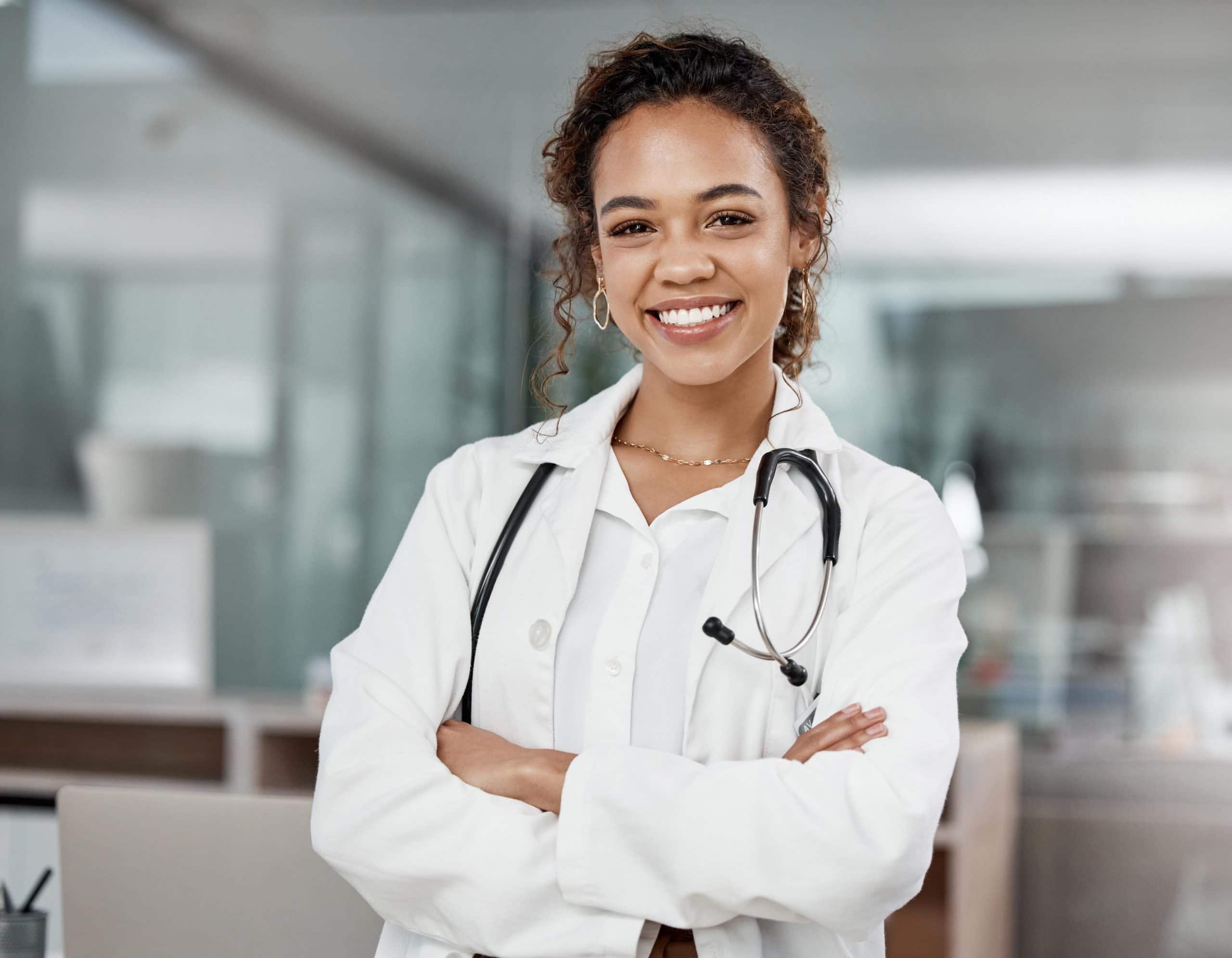 doctor | Cropped portrait of attractive young female doctor sitting with arms crossed in office