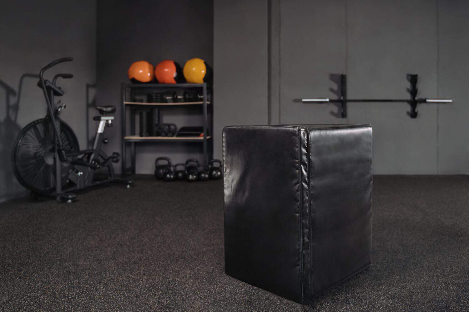 Functional training, workout and crossfit equipment in dark empty gym. Training exercising space interior with modern sports equipment. Jumping box in the foreground. Copy space