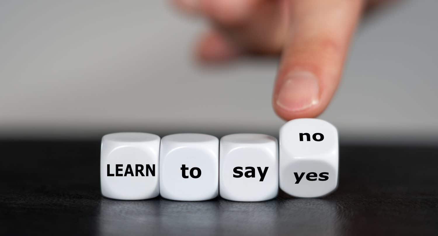 Hand turns dice and changes the expression &#039;learn to say yes&#039; to &#039;learn to say no&#039;.