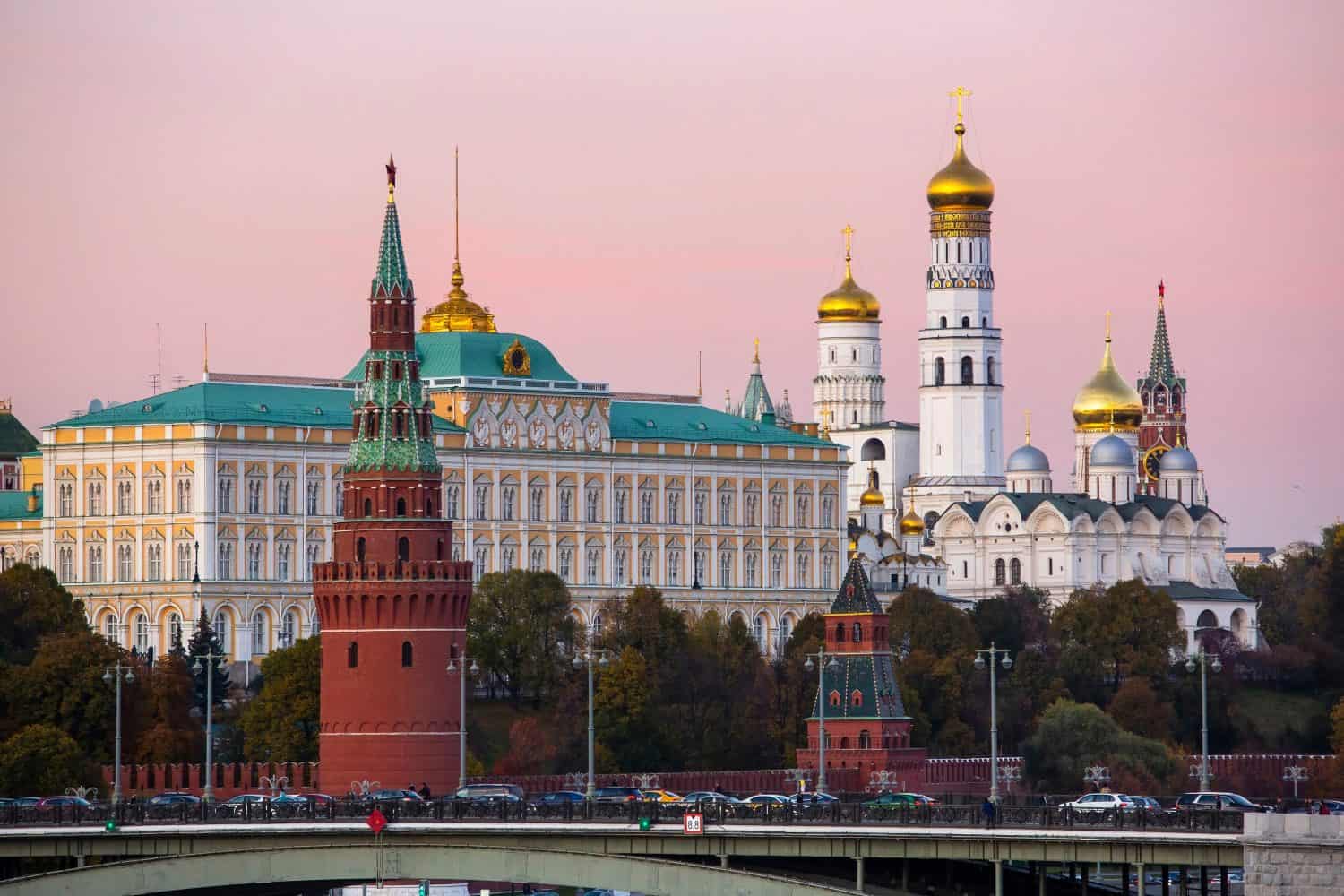 View of the Orthodox Kremlin tower, palace and cathedral at sunset against a pink sky in Moscow, Russia