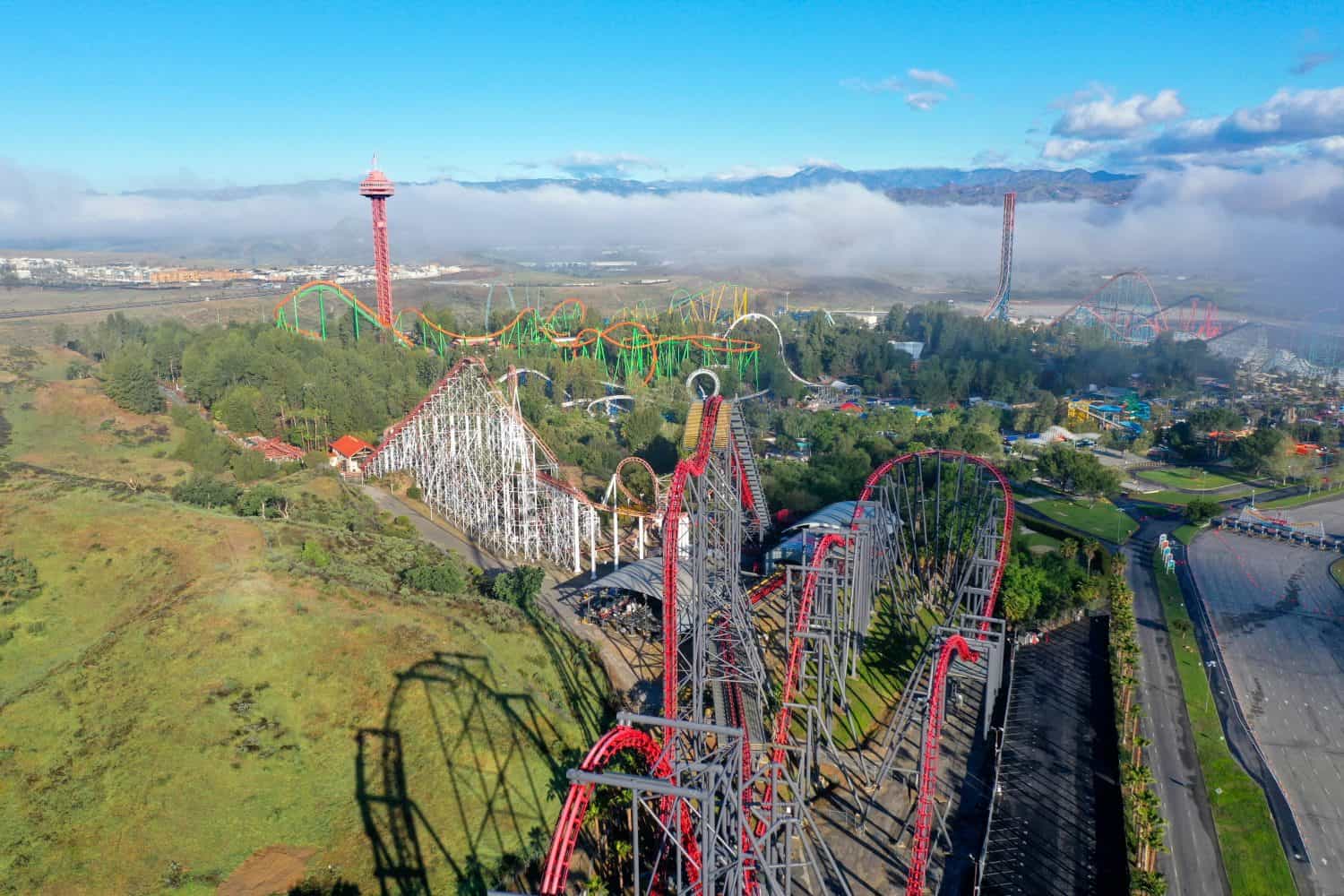 Amusement park with roller coaster rides at golden hour with clouds and shadows. Six Flags Magic Mountain Six Flags Hurricane Harbor Valencia