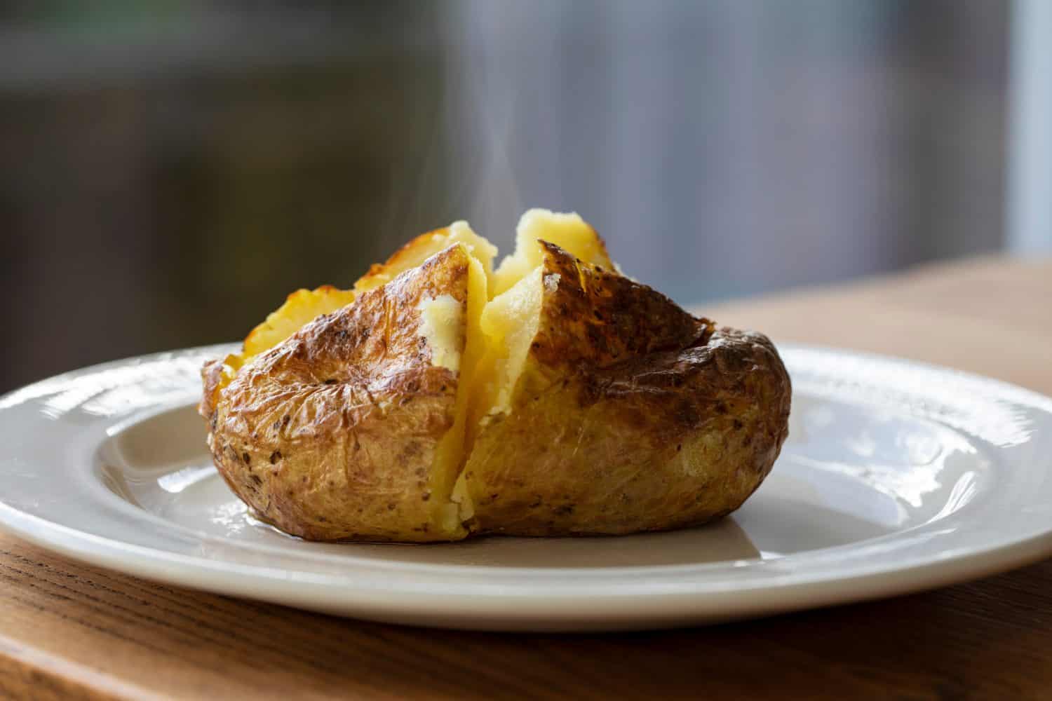 Hot baked potatoes with crispy skin and melted butter