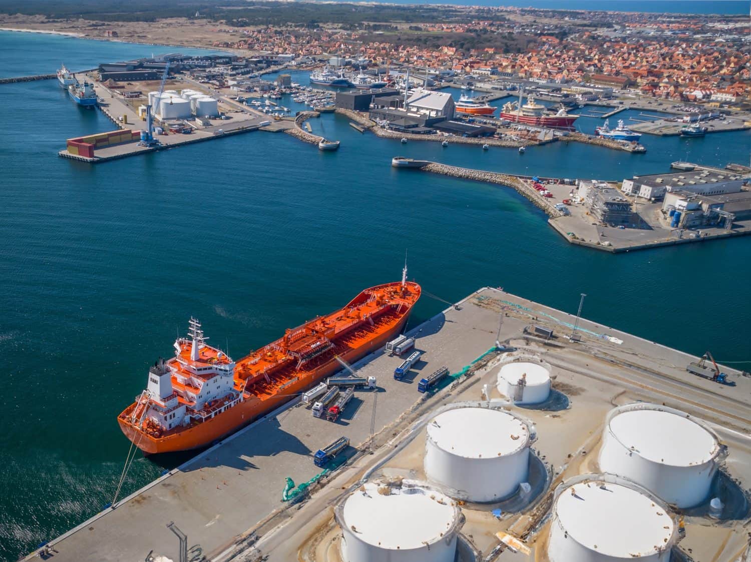 The oil tanker is unloaded into the fuel trucks in the port. The tank fuel truck takes the fuel out of the tank. Unloading from tanker to truck.