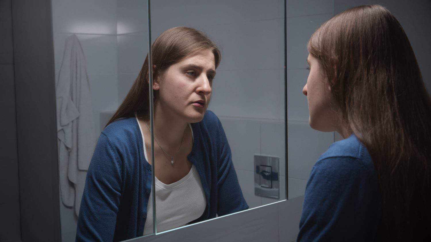 Upset woman standing at sink and thinking of her problems and depression. Concept of depression, stress, mental illness and problems, loneliness and frustration