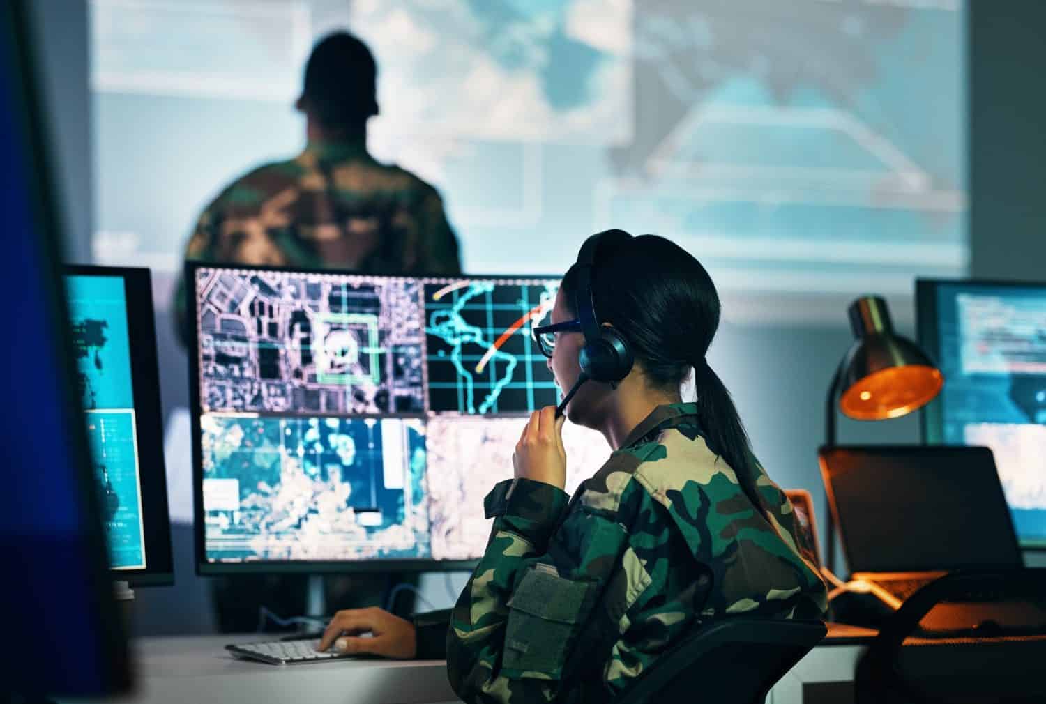 Military command center, computer screen and woman in surveillance, headphones and technology for communication. Security, satellite world map and soldier at monitor in army office in government control room.