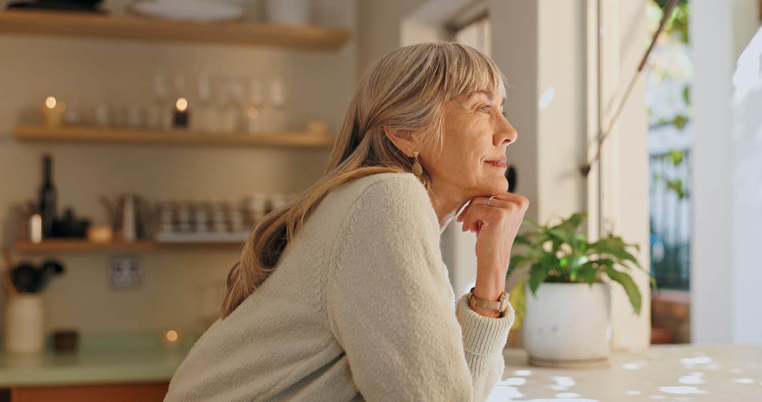 Window, smile and thoughtful old woman at home for retirement, satisfaction and peace at the weekend. Relax senior person and calm with idea of ​​reflection, mindfulness and good memory in the house