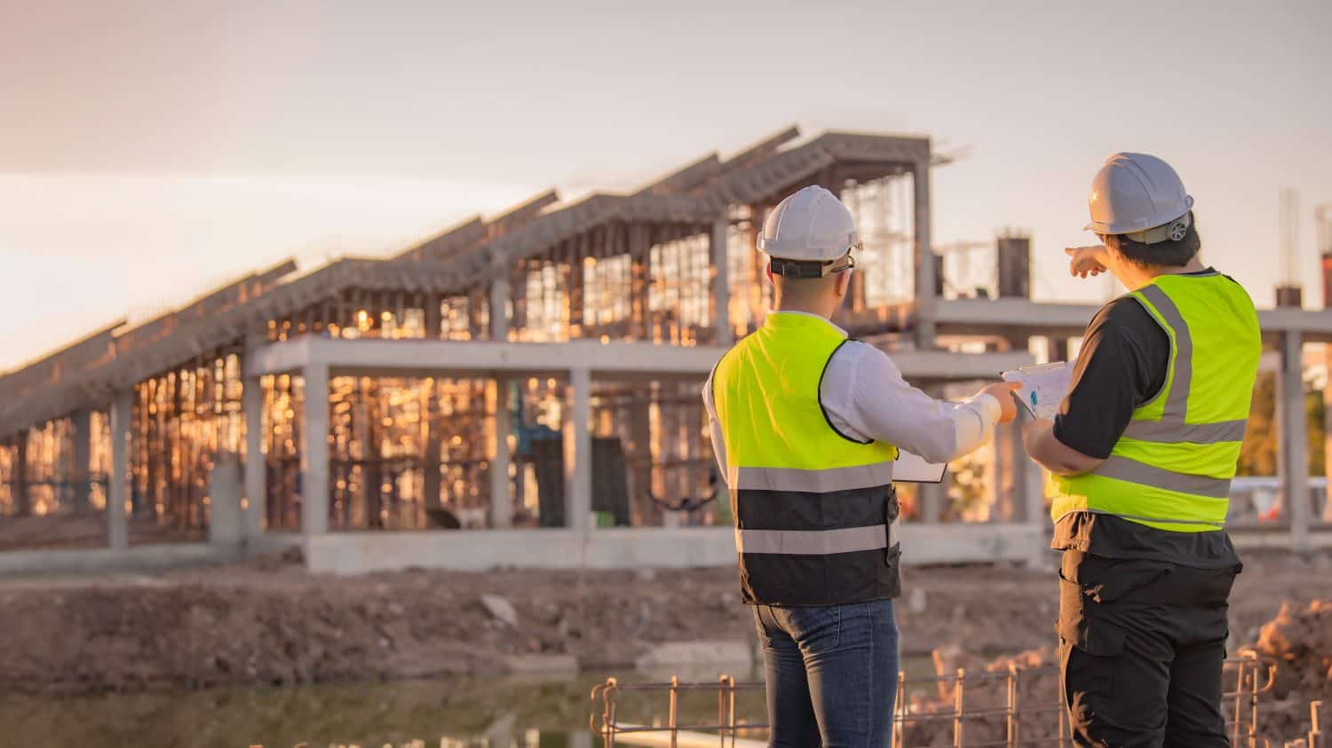 Two Asian engineer working at site of a large building project,Thailand people,Work overtime at construction site,Team of engineer discus at site