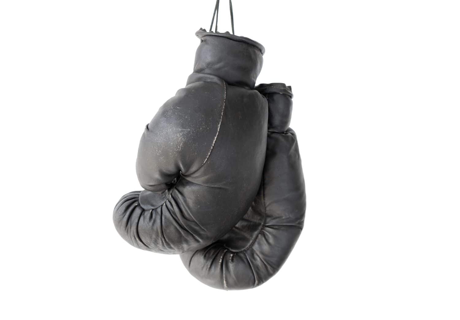 hanging old worn leather boxing gloves isolated on white background