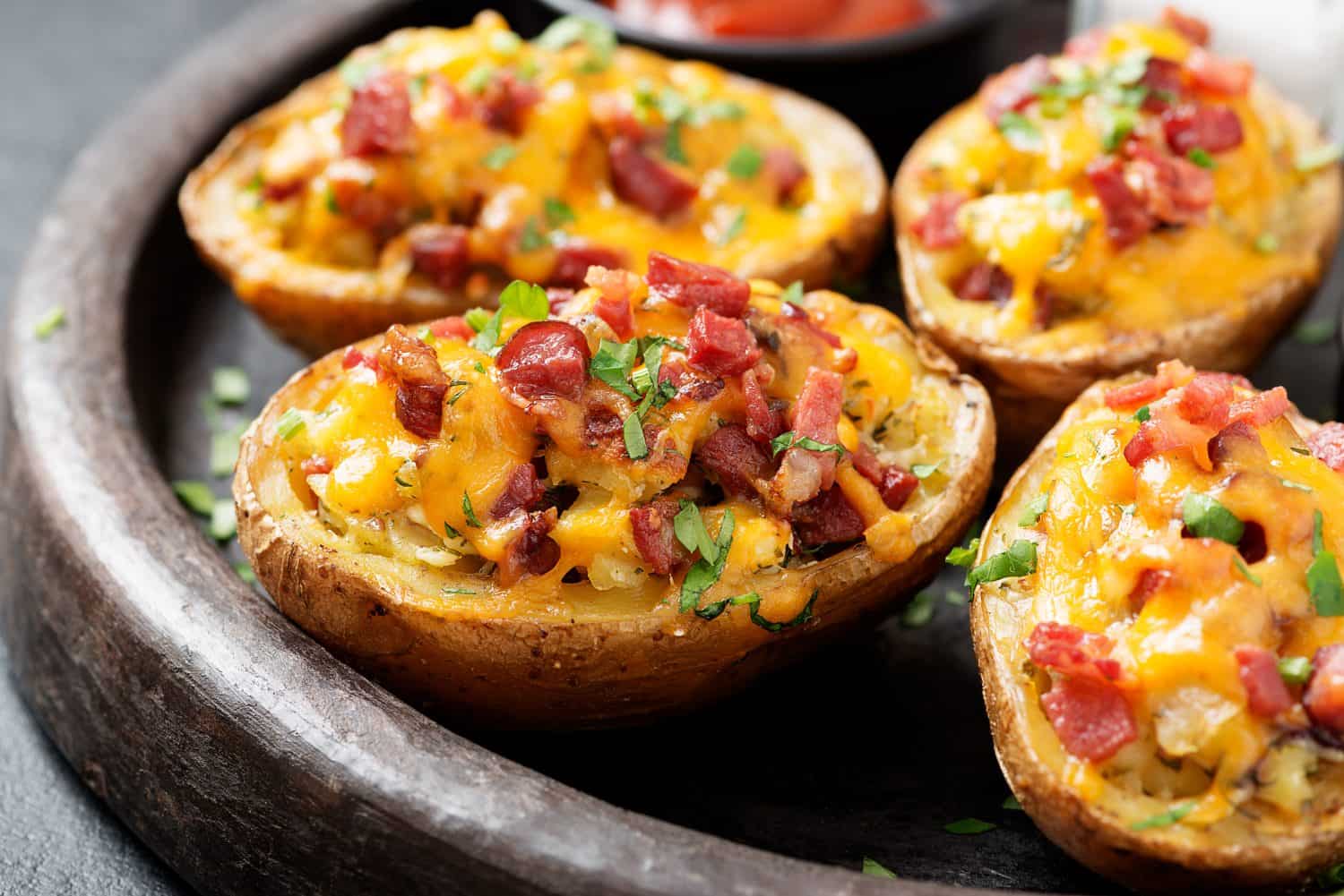 Hot baked potatoes topped with bacon, green onions and cheddar cheese.