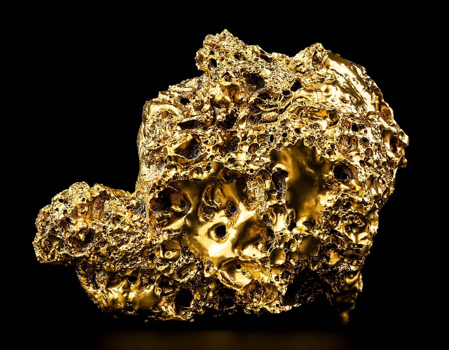 Pure gold from the mine on a black background. Close-up with gold nugget. Finance and business concept.