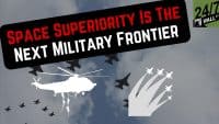 A graphic depicting military aircraft against a cloudy sky features a black banner proclaiming 'SPACE SUPERIORITY IS THE NEXT MILITARY FRONTIER' in red and white text. Silhouettes of fighter jets are visible, along with a white helicopter from which soldiers rappel. White fighter jet icons with vapor trails ascend on the right, and the '24/7 WALL ST' logo is in the top right corner.
