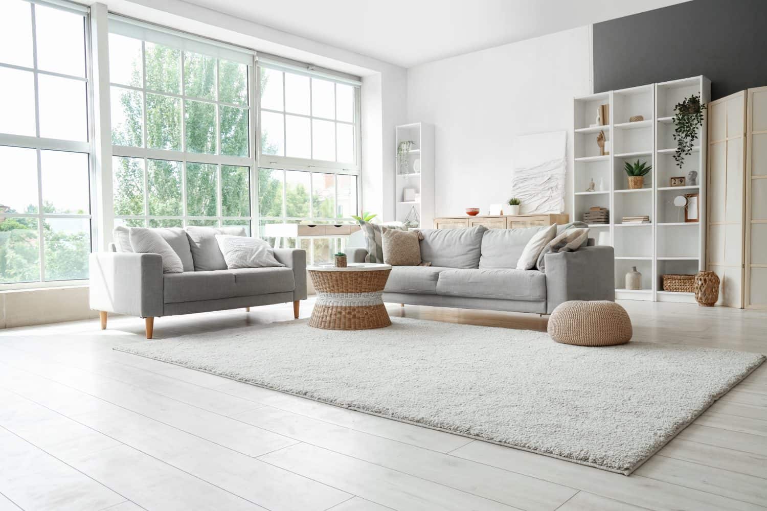 Bright living room interior with sofas, rattan table and soft carpet