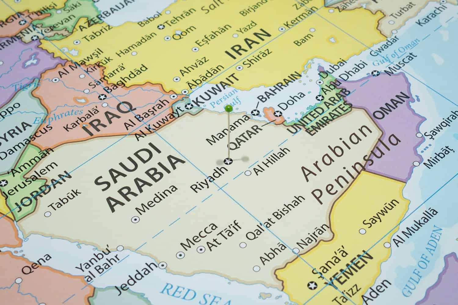 Close up to a Riyadh city with a green pin needle into Saudi Arabia country political map