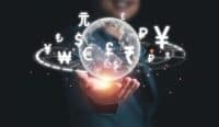A person's hand holds a glowing, translucent globe displaying a world map. Numerous white currency symbols, such as the Yuan, Pound, Dollar, Euro, Rupee, Won, Yen, and Ruble, float around the globe in an orbital pattern. A warm, bright light emanates from beneath the globe, illuminating the hand, against a dark, blurred background with subtle orange glowing specks.